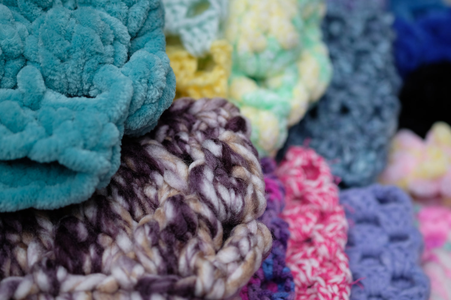 several cowls lined up in a row with each being a different colour (green, pink, yellow, purple, blue, etc)